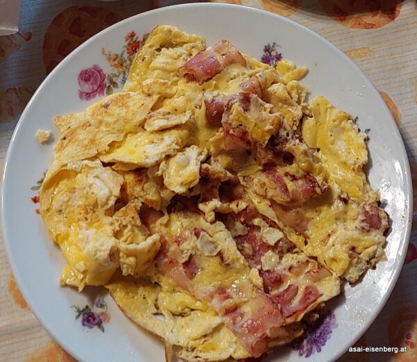Omelette oder Rührei von 3 Eiern mit Käse Und Schinken, serviert